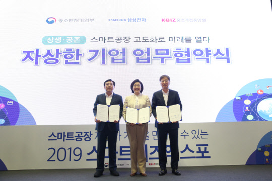 11일 서울 코엑스에서 삼성전자를 7호 자상한 기업으로 선정하는 업무협약식을 마치고 박영선 중기부 장관(가운데), 김기문 중기중앙회장(왼쪽), 윤부근 삼성전자 부회장이 기념촬영을 하고 있다.  중기부 제공
